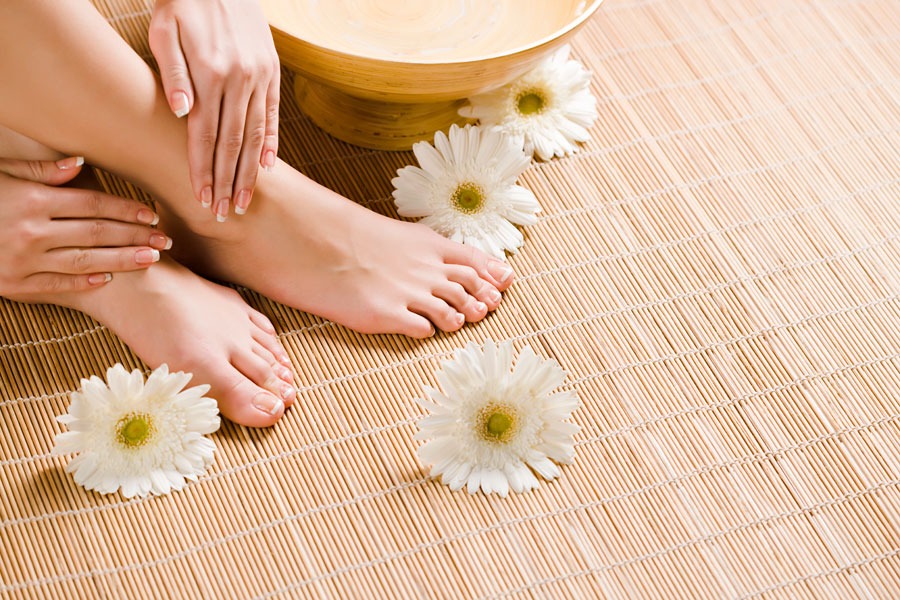 foot of a female and jasmine flowers around